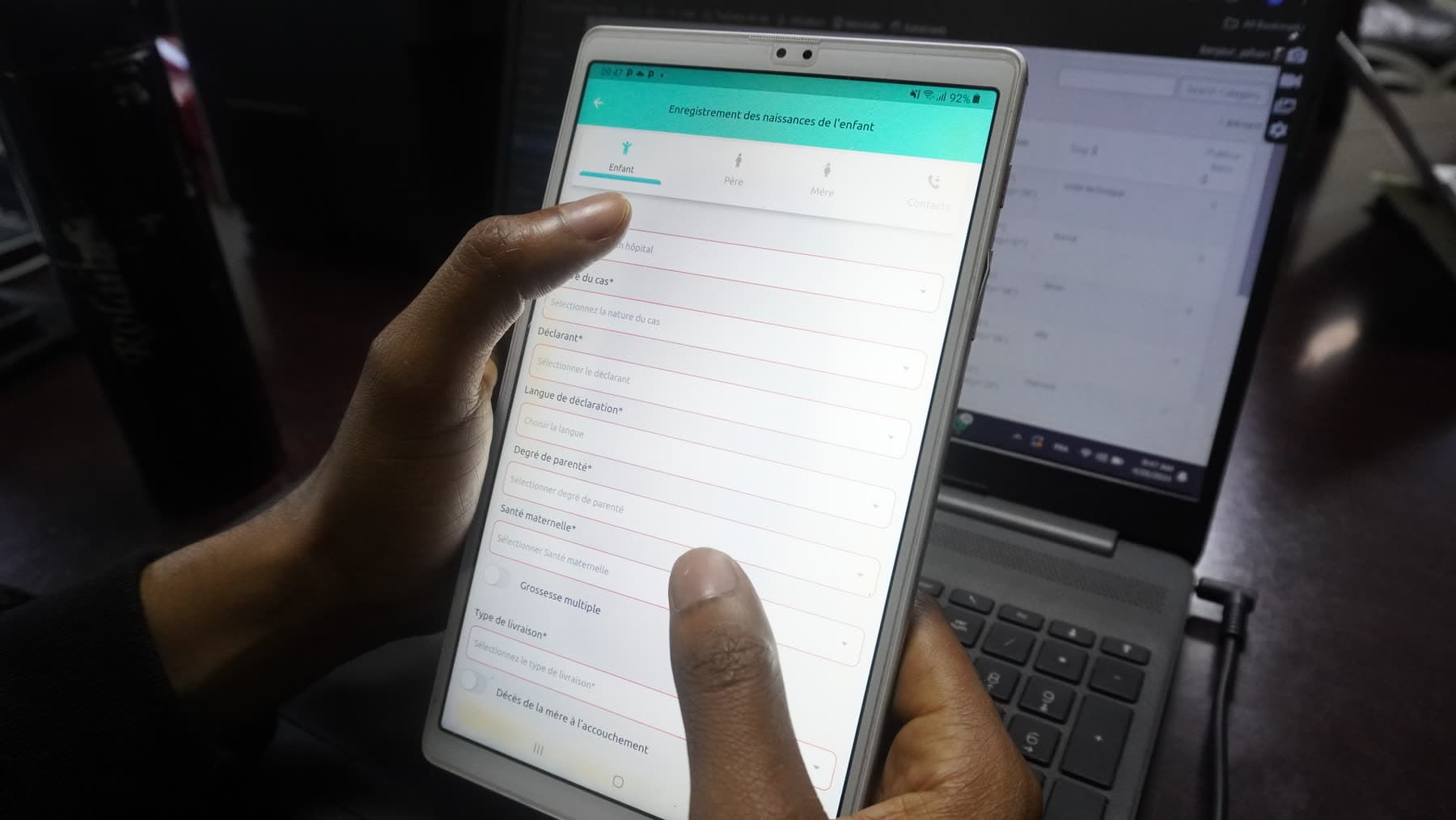 eGov staff training health workers on the platform — hands on a tablet alongside a laptop